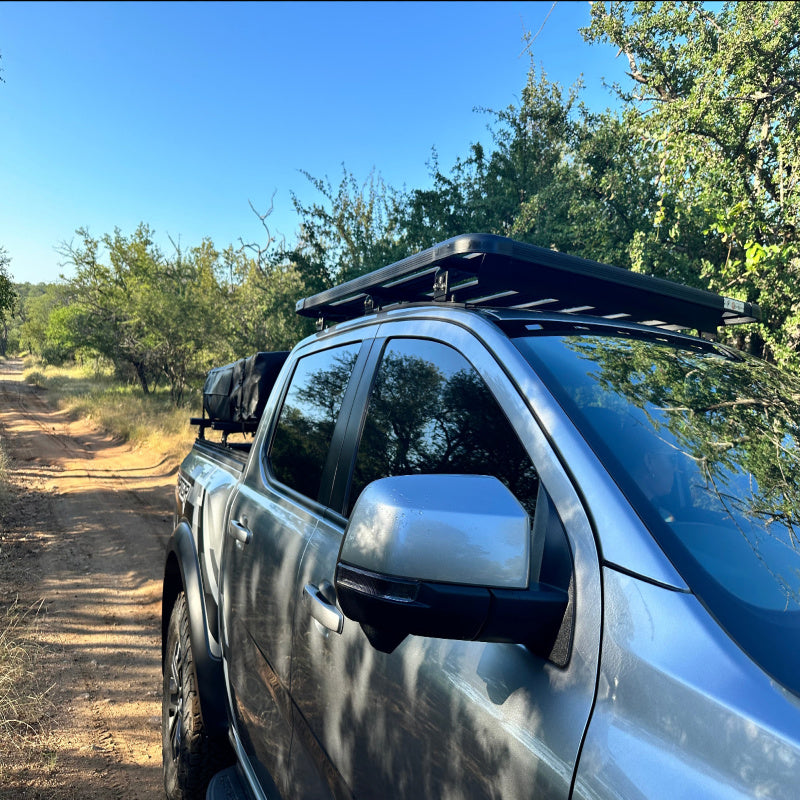 Eezi awn ford ranger roof rack on truck driving down dirt road front left view
