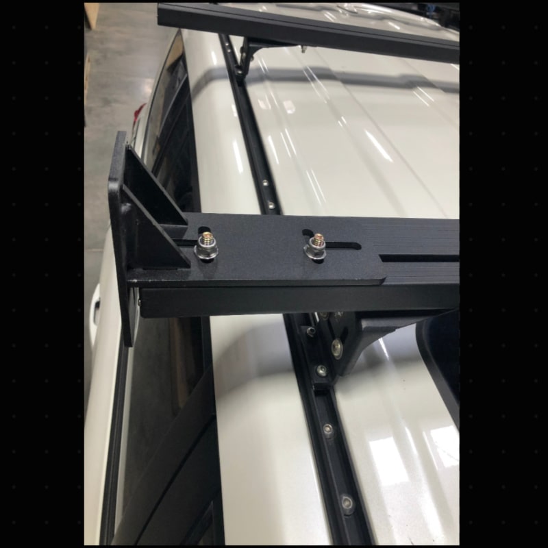 Eezi k9 load bar mount overlanding bracket in black metal top down front view on suv in garage