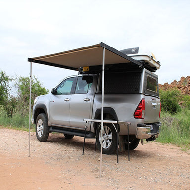 Eez swift awning front left view open set up outside with table and truck