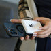 Lion claw portable power station in white with black logo and person holding a phone attaching both.