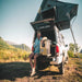 National luna 35l mini fridge outside in truck with roof top tent and camper having a drink